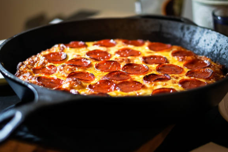 Pepperoni pizza baked in a cast iron skillet.